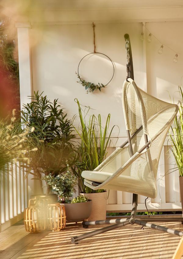 Heller Hängesessel mit Pflanzen auf Boho Balkon Heller Hängesessel mit Pflanzen auf Boho Balkon