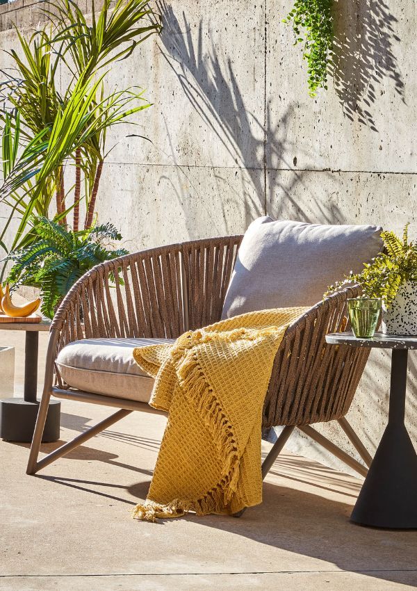 Rattan Sessel mit gelber Fransen-Decke Rattan Sessel mit gelber Fransen-Decke