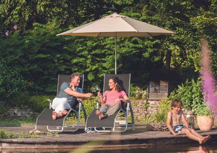 Familie sitzt unter Sonnenschirm