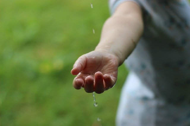 Hand mit Wassertropfen